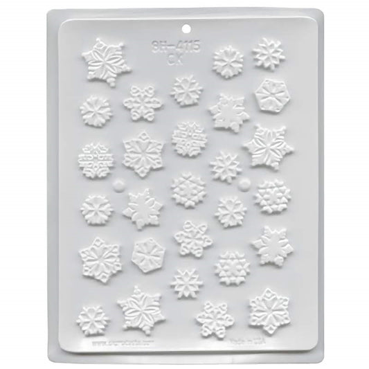 A white hard candy mold with cavities shaped like snowflakes. The snowflakes are in a variety of shapes and sizes. 