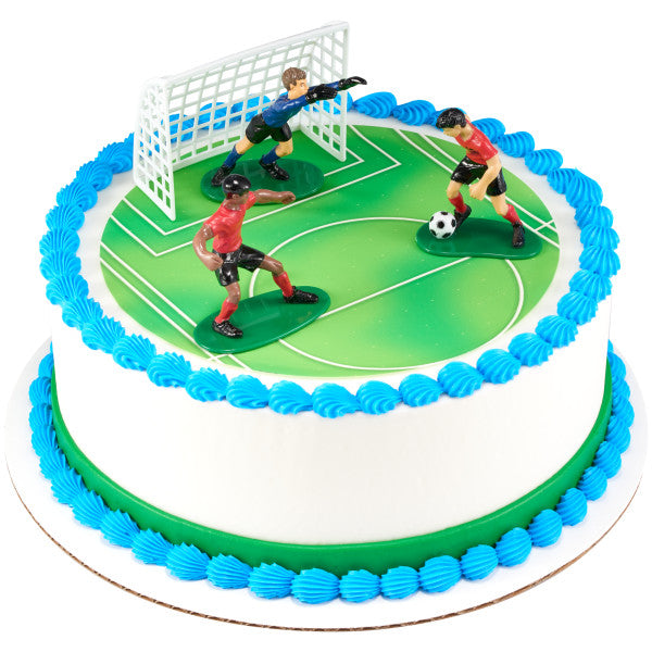 White round soccer cake decorated with a green field, blue trim, and three soccer player toppers near a goal.