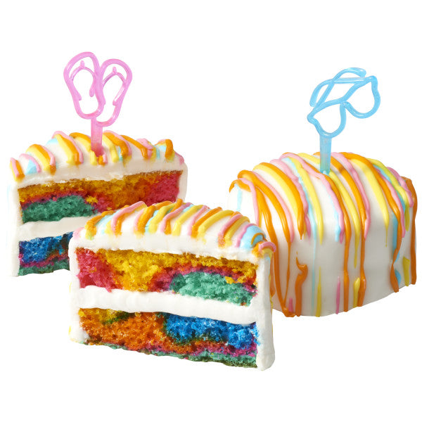 Slices of rainbow cake and a small decorated cake featuring colorful summer-themed DecoPics, including flip-flops and sunglasses.