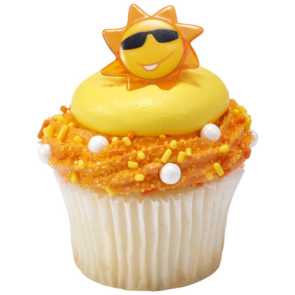 A cupcake decorated with bright frosting and sprinkles, topped with a sun face ring.