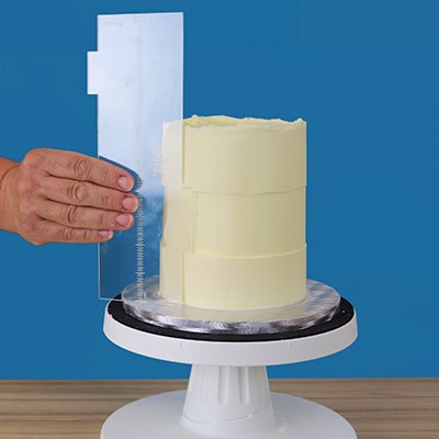 PME Latitude Ring Side Scraper in use on a buttercream cake, demonstrating its ring-texture pattern effect.