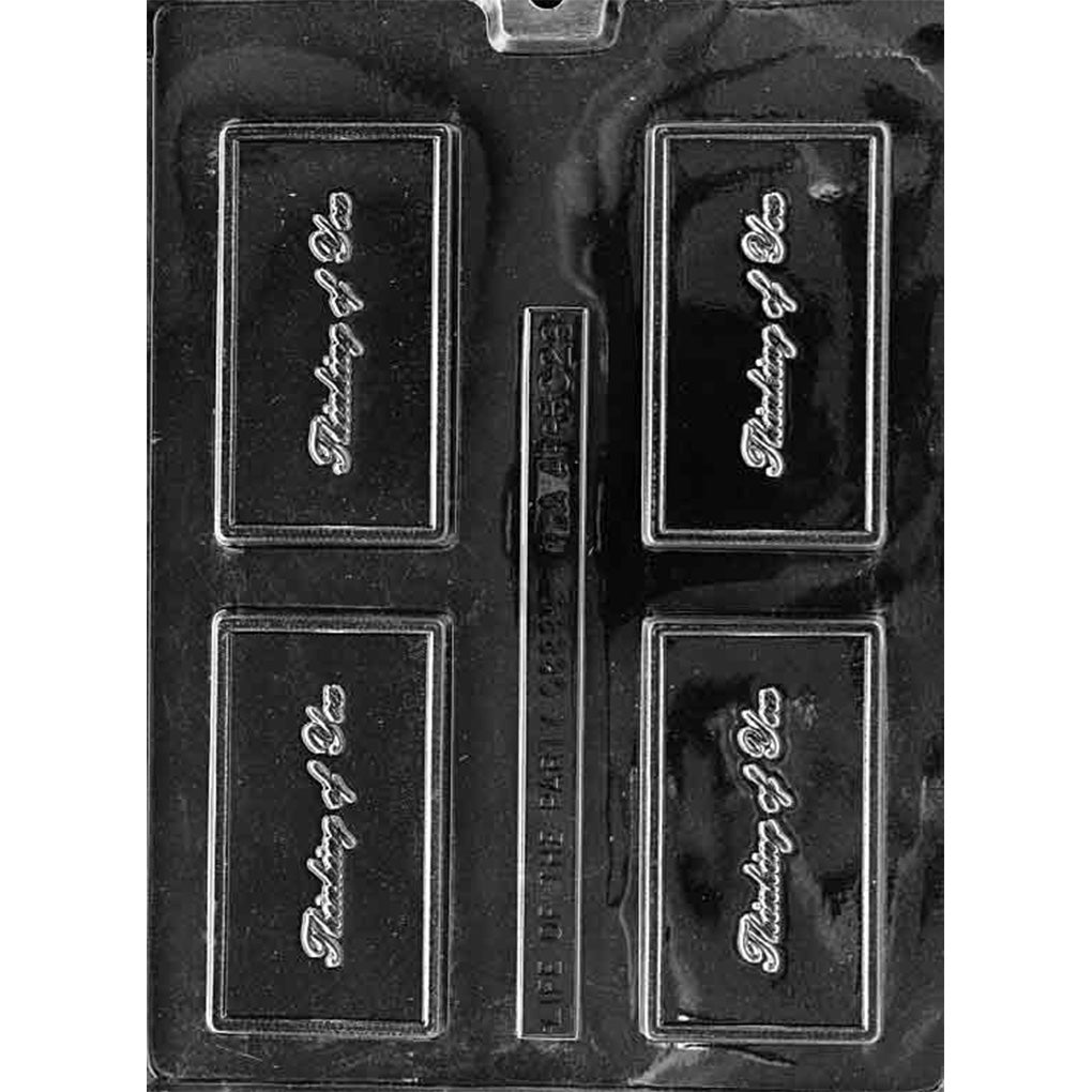 Clear plastic chocolate bar mold photographed on a black background, showing four rectangular cavities with a raised border and “Thinking of You” script in the center.