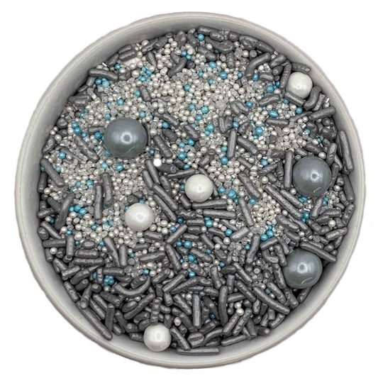 A bowl of sprinkles featuring white sugar pearls, slate-colored sixlets, slate jimmies, silver and blue nonpareils, and white sanding sugar, perfect for adding a sophisticated sparkle to desserts.