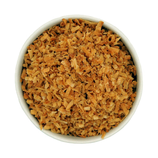 Top-down view of a white bowl filled with toasted coconut, showing texture and even toasting.