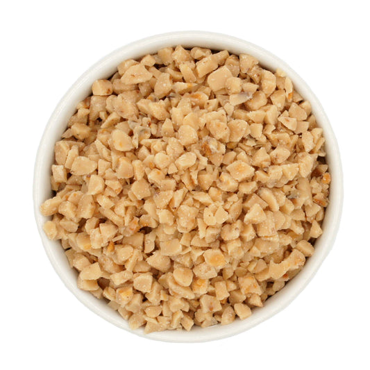 Top-down view of toffee candy crunch in a white bowl, featuring uniform golden bits ideal for chocolate, cookies, and ice cream