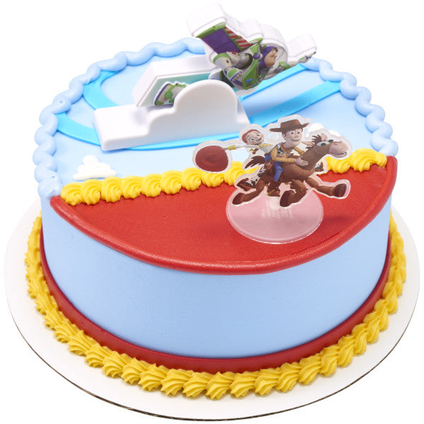 Round Toy Story cake with blue sides, red top, and yellow borders, decorated with a Buzz Lightyear flying topper and a Woody and Jessie standee.