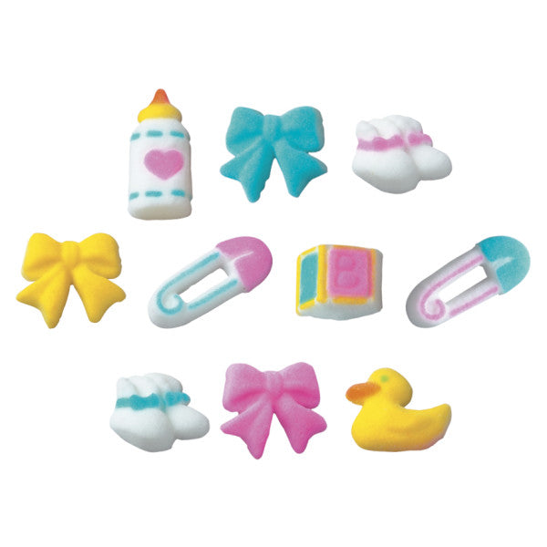 Assorted pastel baby-themed pressed sugar decorations including bottles, booties, bows, pins, ducks, and blocks in pink, blue, and yellow.