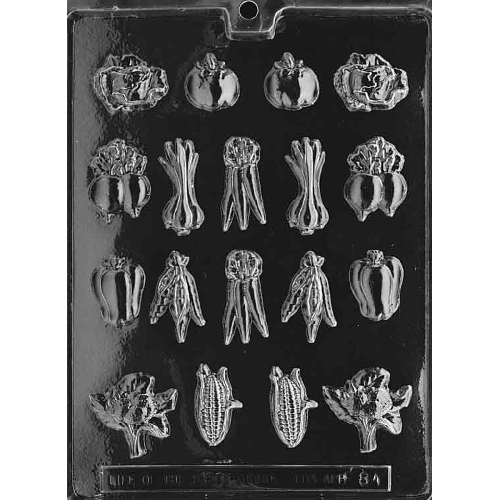 Clear plastic chocolate mold with many bite-sized vegetable-shaped cavities, including lettuce leaves, tomatoes, onions, carrots, peppers, beets, broccoli, and corn.