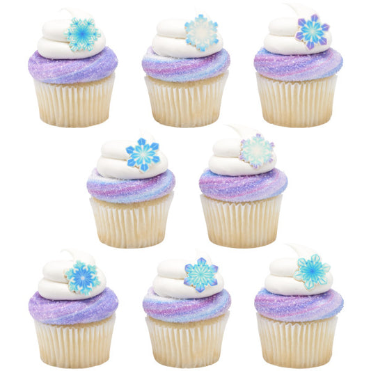 Eight cupcakes with purple sugar sprinkles and white frosting, topped with assorted pressed sugar snowflakes.