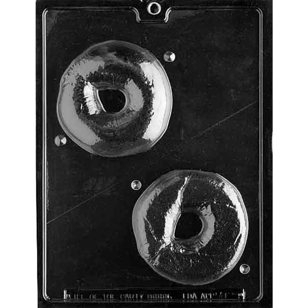 Clear plastic 3D bagel chocolate mold photographed on a black background, showing two large ring-shaped cavities with a pre-marked line for cutting the mold into two halves.