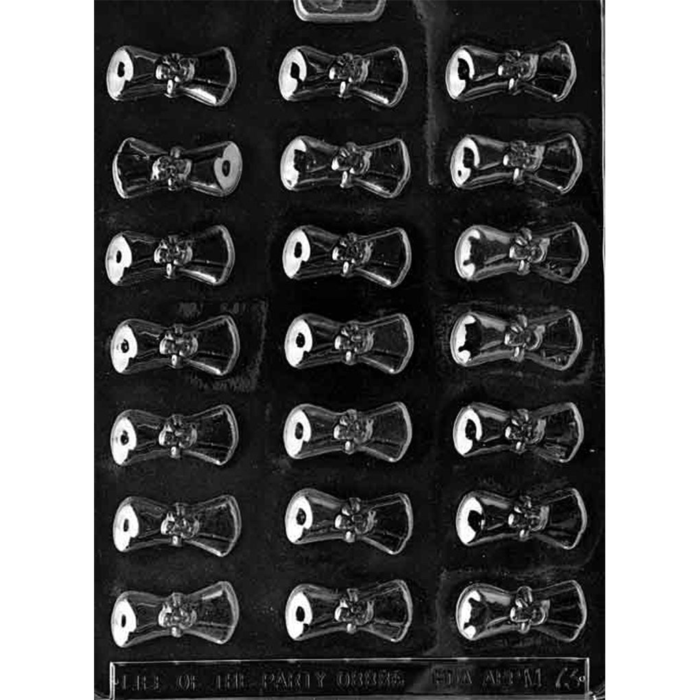 Clear plastic chocolate mold with eighteen small rolled diploma scroll cavities arranged in a grid, each with a tied ribbon detail in the center, on a dark background.