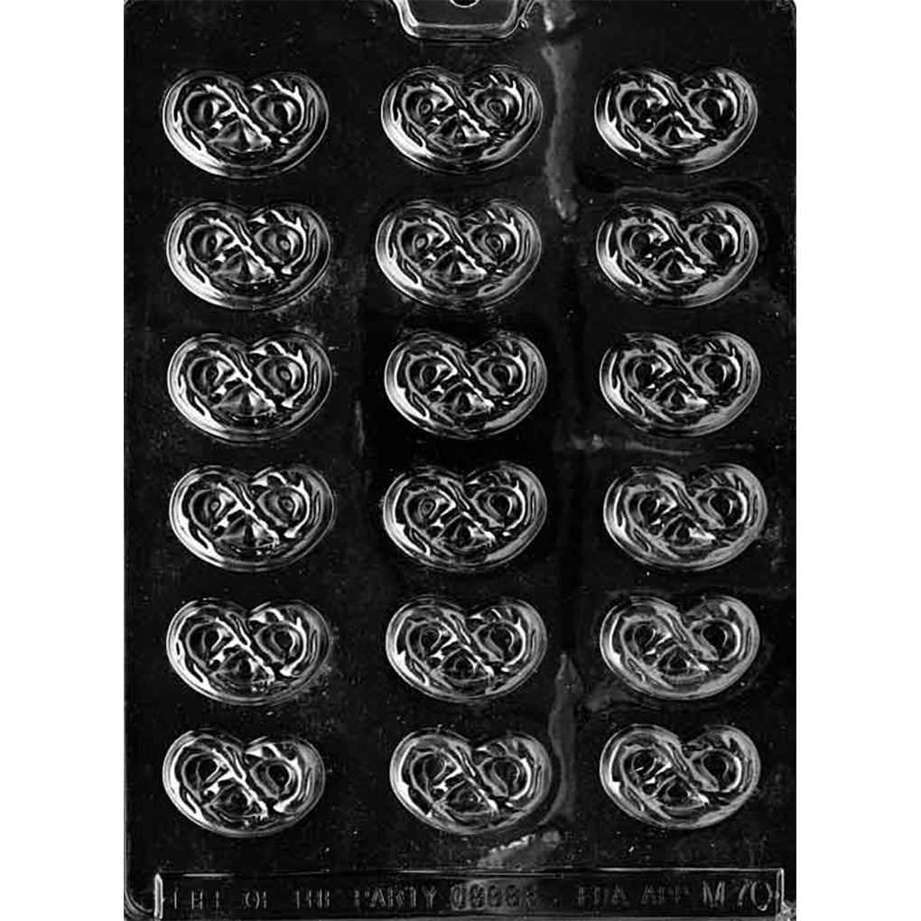 Clear plastic chocolate mold photographed on a black background with multiple pretzel-shaped cavities in rows, each cavity showing raised twisted pretzel lines.