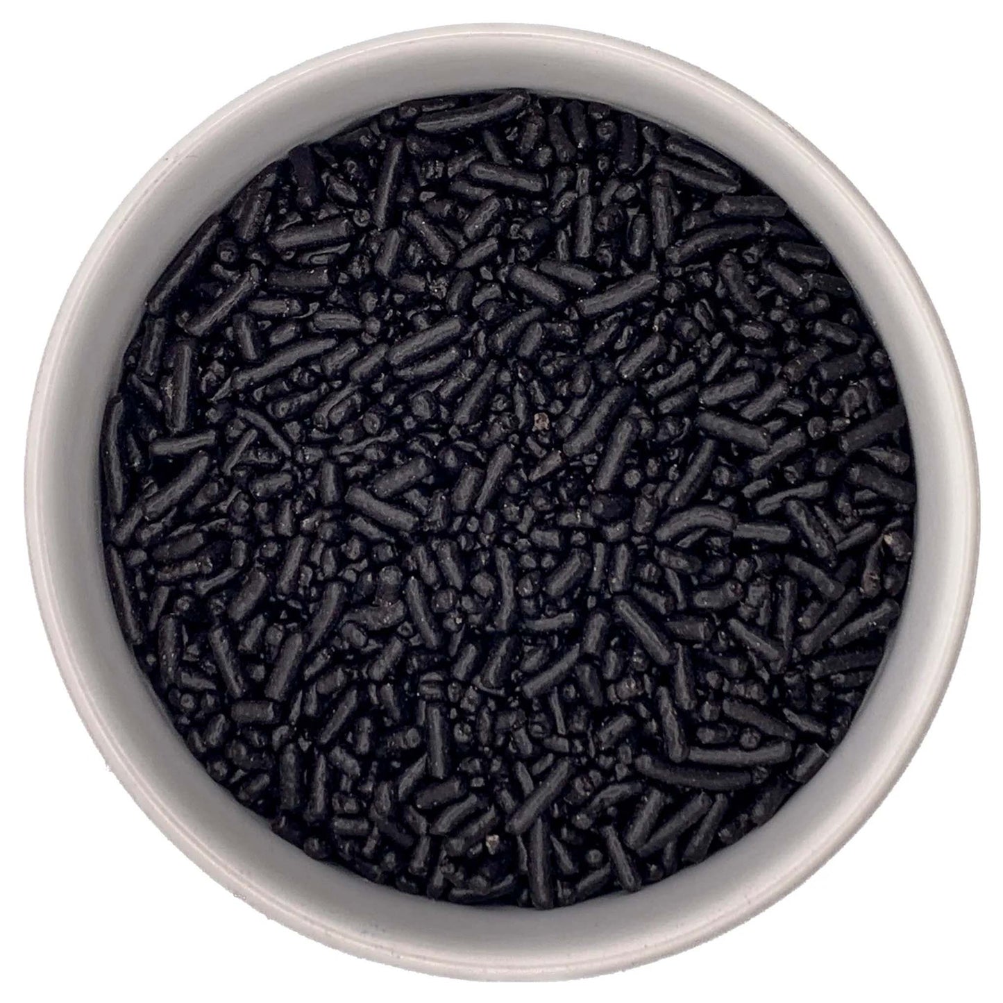 Overhead view of a white bowl filled with black jimmies sprinkles, showing small rod-shaped pieces and tiny bits clustered together.