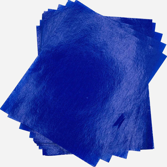 Overlapping stack of deep blue 4" x 5" wax caramel and taffy wrapper sheets displayed against a white background.