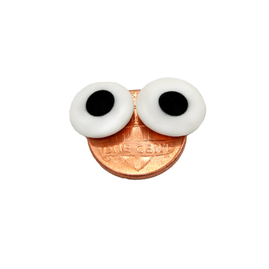 Two 1/2" edible candy eyes on a penny, displaying their size and playful look for cookies, cupcakes, and themed desserts.