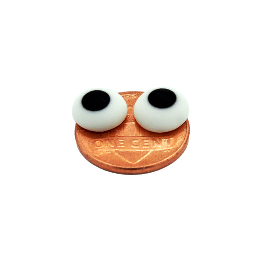Two 3/8" edible candy eyes on a penny, showing size and thickness for baking use.