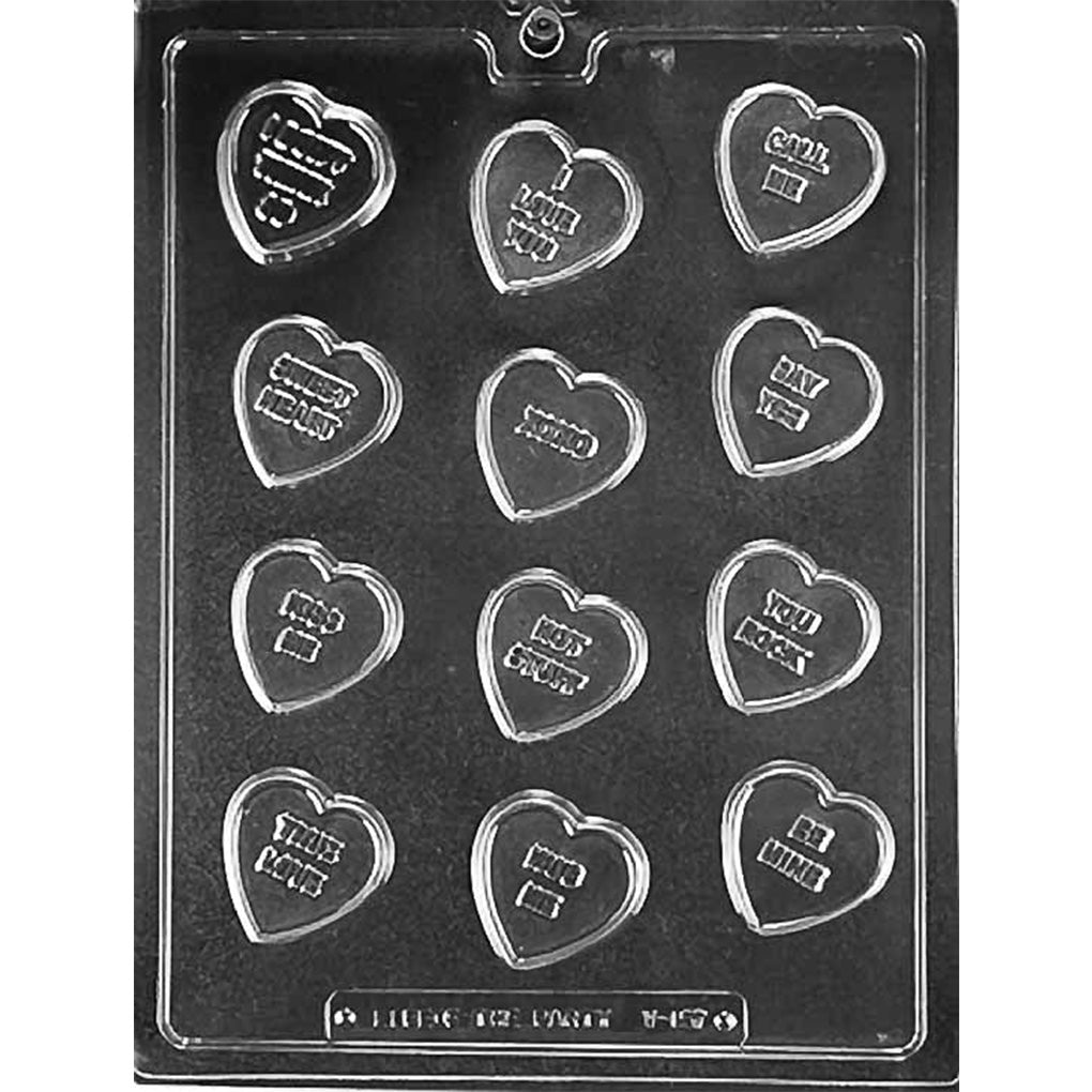 Clear chocolate mold with 12 small heart-shaped cavities, each featuring a raised phrase such as Be Mine, XOXO, Kiss Me, or Hot Stuff.