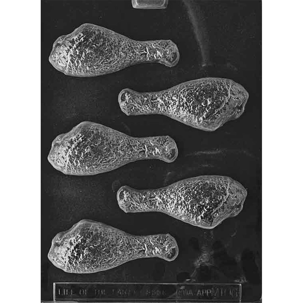 Clear plastic chocolate mold photographed on a black background with five chicken drumstick-shaped cavities, each showing textured “skin” detail and a rounded bone end.