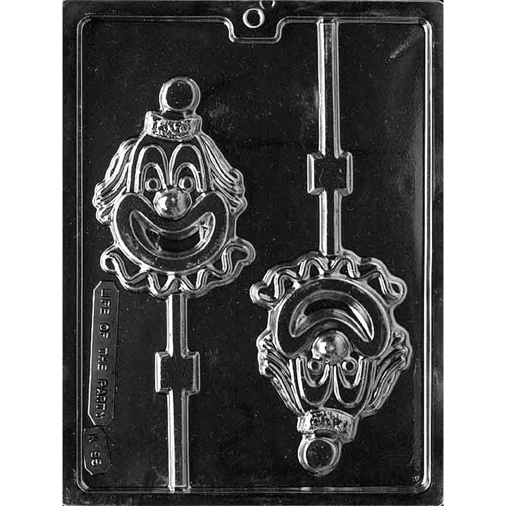 Two-cavity clown face chocolate lollipop mold with smiling faces, round noses, wavy hair, small hats, ruffled collars, and stick channels; each cavity measures 4 1/2 x 3 1/8 x 5/8 inch.