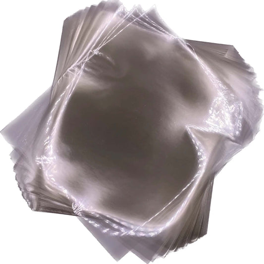 Overlapping stack of clear 4" x 4 ½" cellophane caramel wrappers with smooth, glossy surfaces.