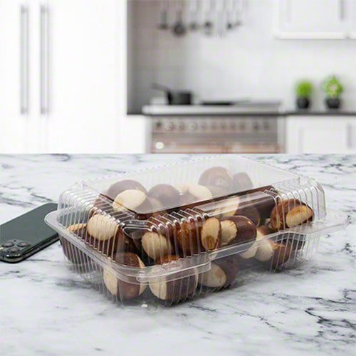 Clear hinged deli container with ribbed sides sitting on a kitchen counter filled with pretzel bites
