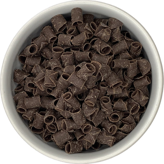 Bowl filled with dark chocolate curls, showing their rolled texture and rich chocolate color.