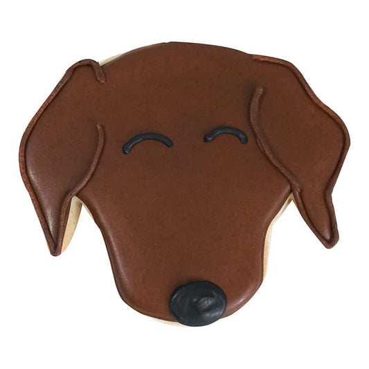 Decorated dog cookie with brown icing, black details, and a cute puppy expression.