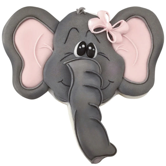 Decorated elephant face-shaped cookie with gray icing, pink ears, big eyes, and a pink bow detail.