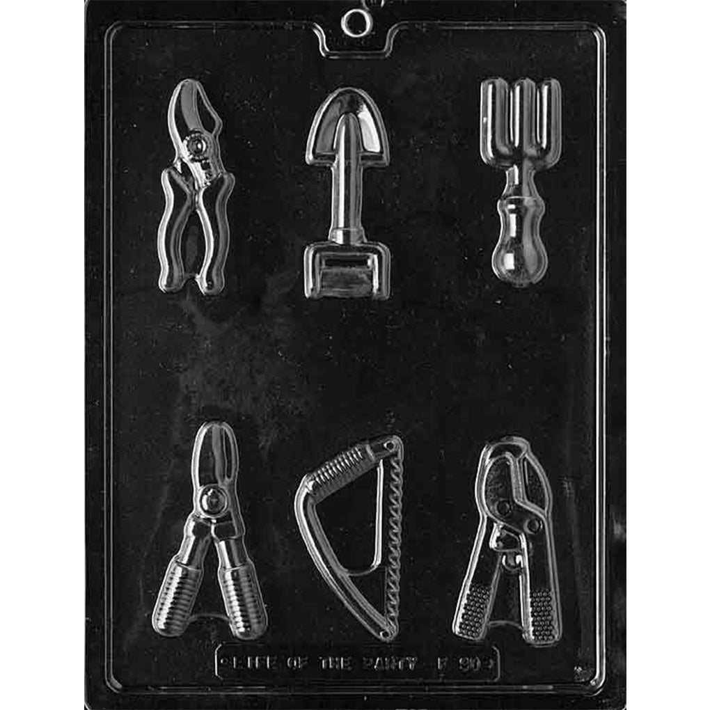 Clear plastic chocolate mold with six gardening tool shapes including pruners, a hand shovel, a three-prong cultivator, a small saw, and clippers.