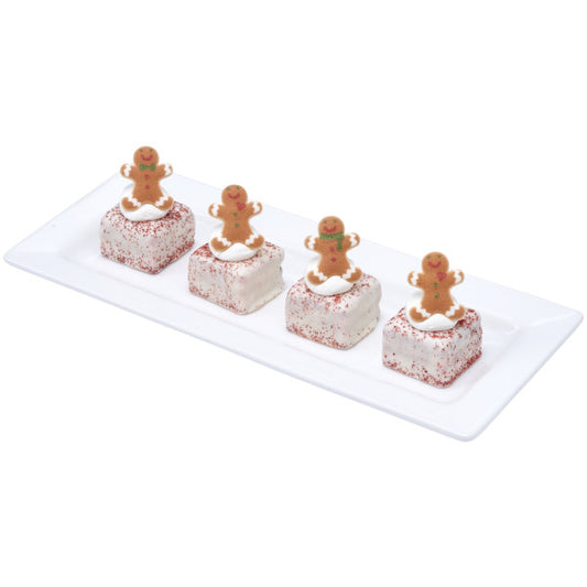 White chocolate-dipped square treats topped with red sugar and pressed sugar gingerbread men, displayed on a white rectangular platter.