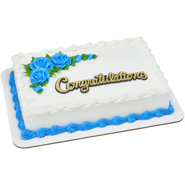 Rectangular white sheet cake with blue rose decorations and “Congratulations” gold cake topper layon.