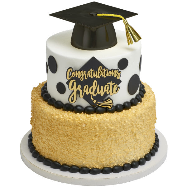 Two-tier graduation cake with black cap topper and gold “Congratulations Graduate” plaque.
