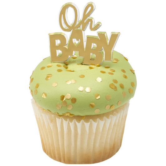 Cupcake topped with green frosting, gold hexagon confetti, and a gold "Oh Baby" pick.