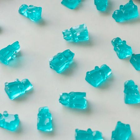 Shiny blue gummy bears spread out without sticking, treated with LorAnn Finishing Anti-Stick Coating for a smooth finish.