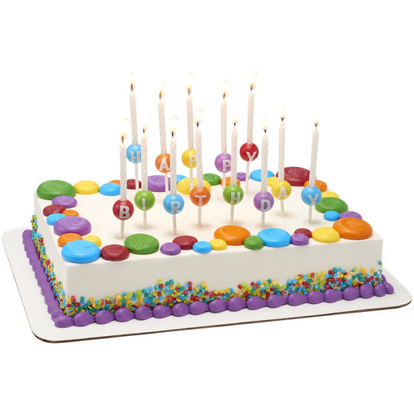 Birthday cake decorated with Bakery Crafts Happy Birthday 3D candle holder set and spiral candles, featuring bold letters and vibrant colors
