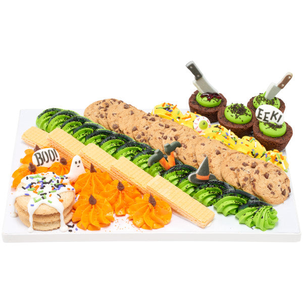 A Halloween-themed dessert platter featuring cookies, cupcakes, and wafers decorated with green and orange frosting, sprinkles, and topped with edible sugar axes and knives.