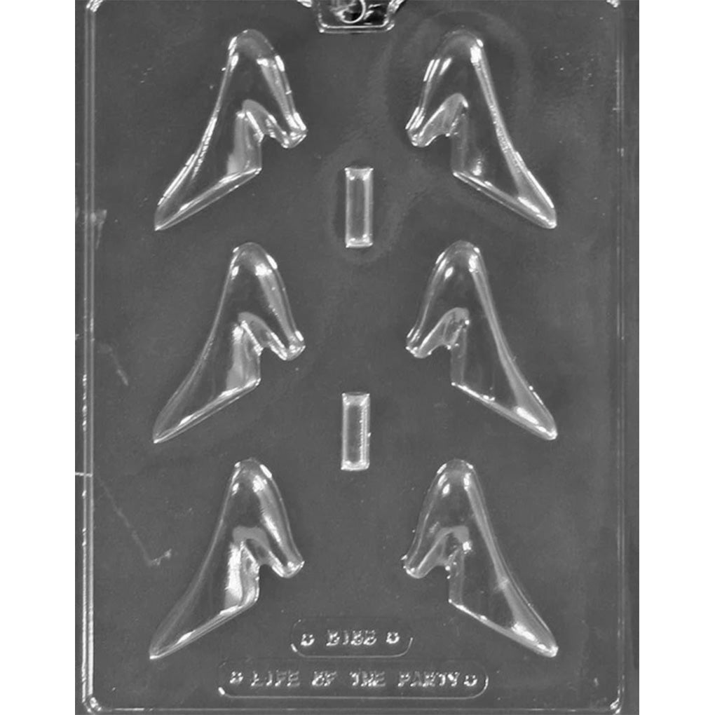 Clear plastic chocolate mold photographed on a dark background with six small high heel shoe-shaped cavities arranged in two columns, each forming a 3D pump silhouette.