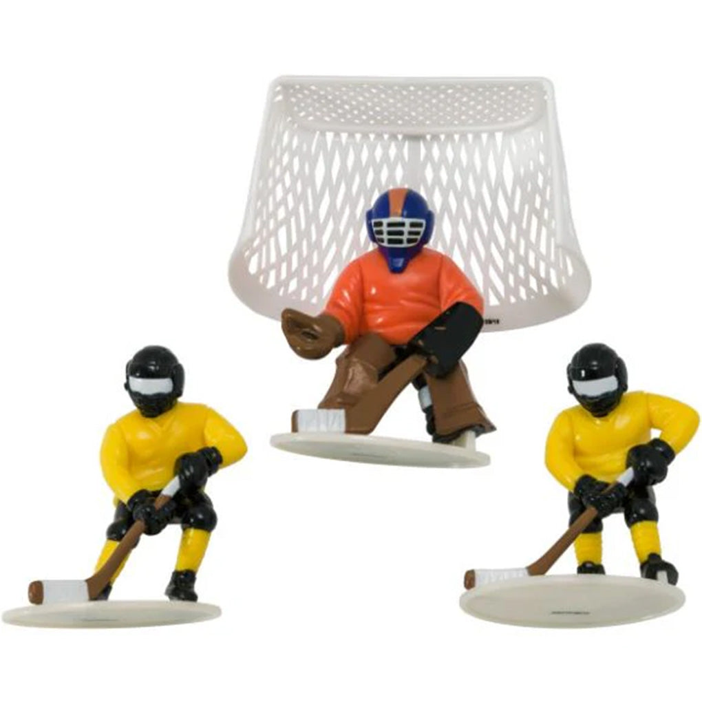 Hockey cake topper set showing two yellow-uniform skater figurines holding sticks, one goalie figurine in an orange jersey, and a white plastic goal net on a white background.