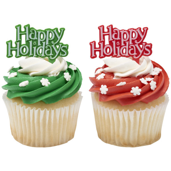 Two cupcakes with green and red icing, each topped with a “Happy Holidays” pick and white snowflake sprinkles.