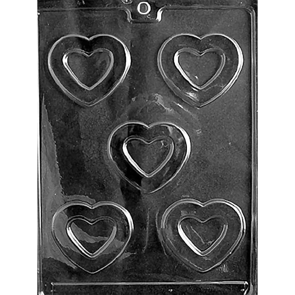 Clear plastic chocolate mold with five heart-shaped cavities, each featuring a smaller raised heart inside a larger open heart outline.