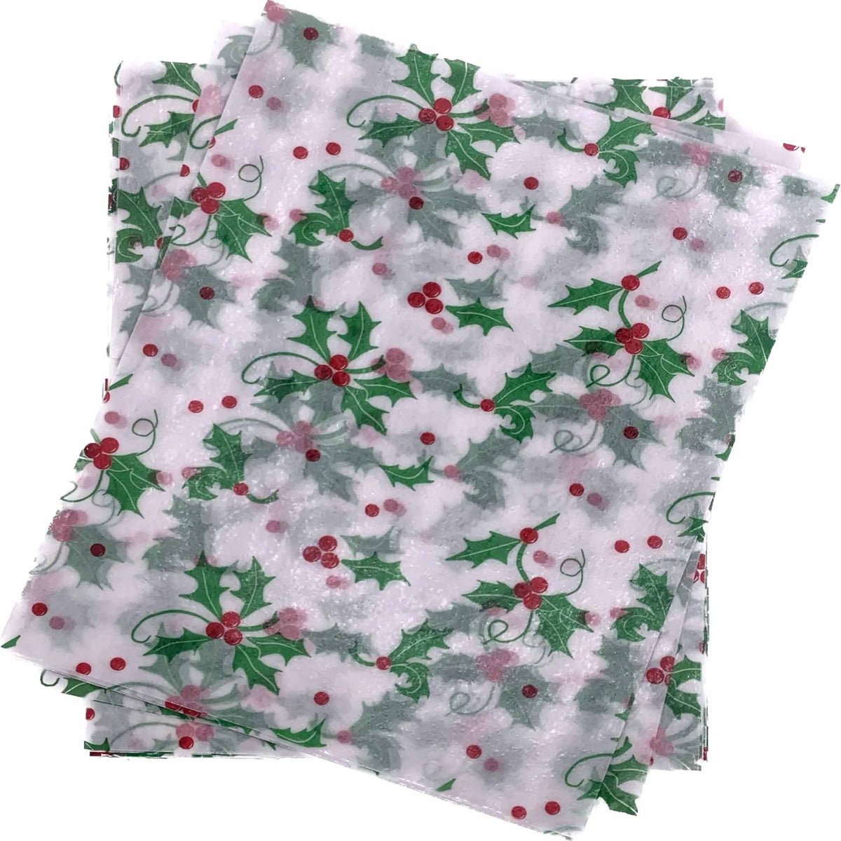 Overlapping stack of white 4" x 5" wax caramel wrappers printed with a repeating pattern of green holly leaves and red berries.