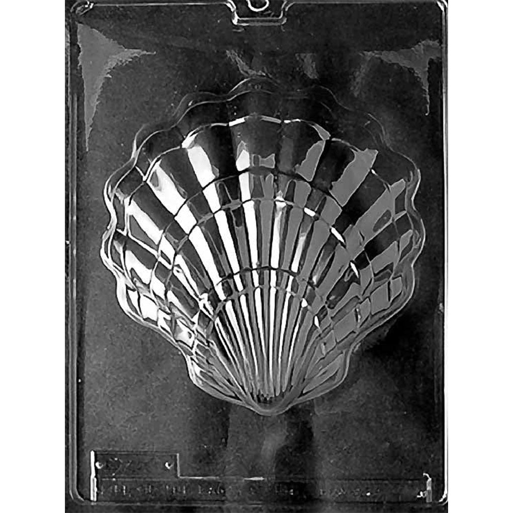 Clear plastic chocolate mold with one large scallop shell cavity featuring deep ribbed lines and a scalloped edge, shown on a dark background.