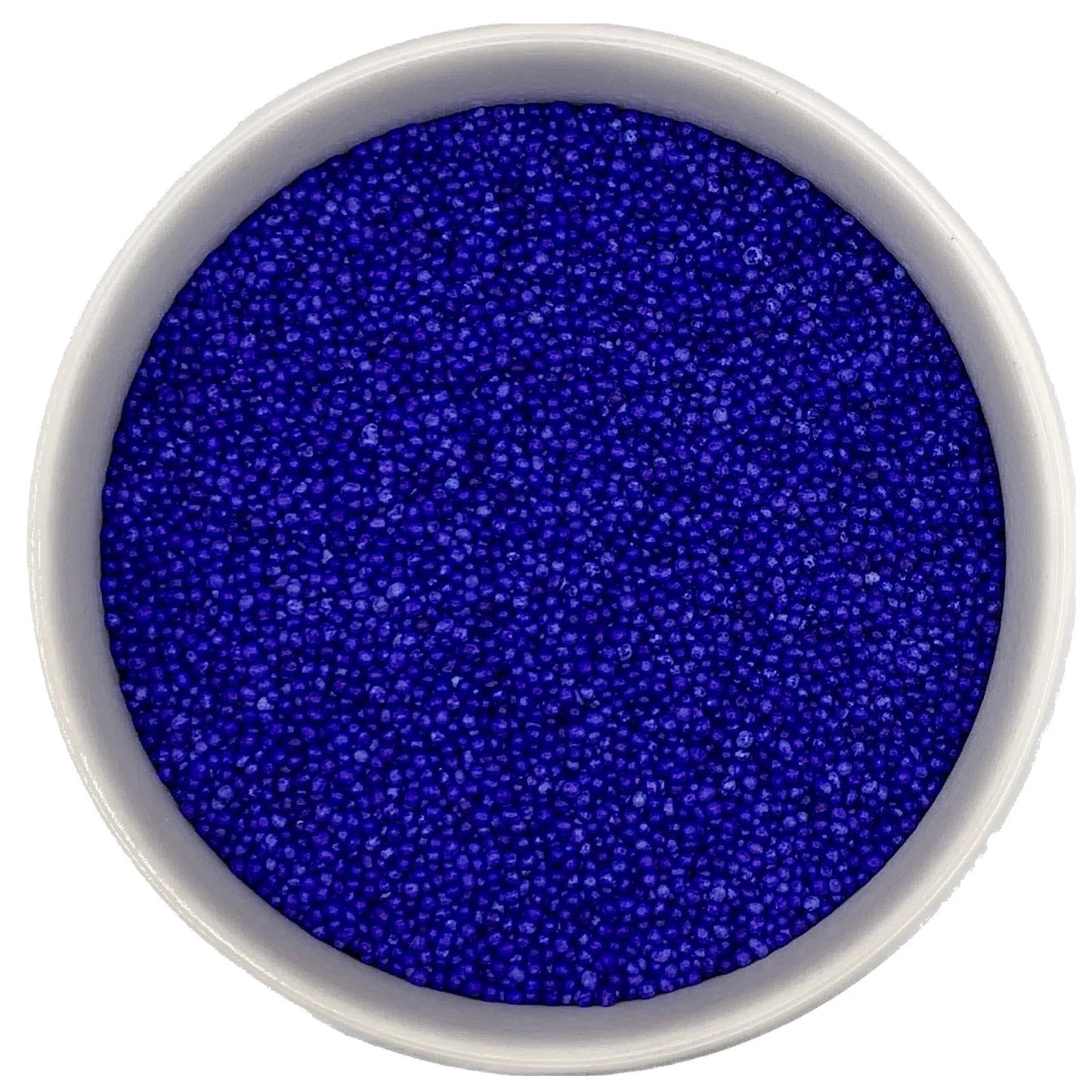 Top-down view of a white bowl filled with lavender non-pareils, showing tiny round sprinkle beads in a vivid blue-violet lavender shade.