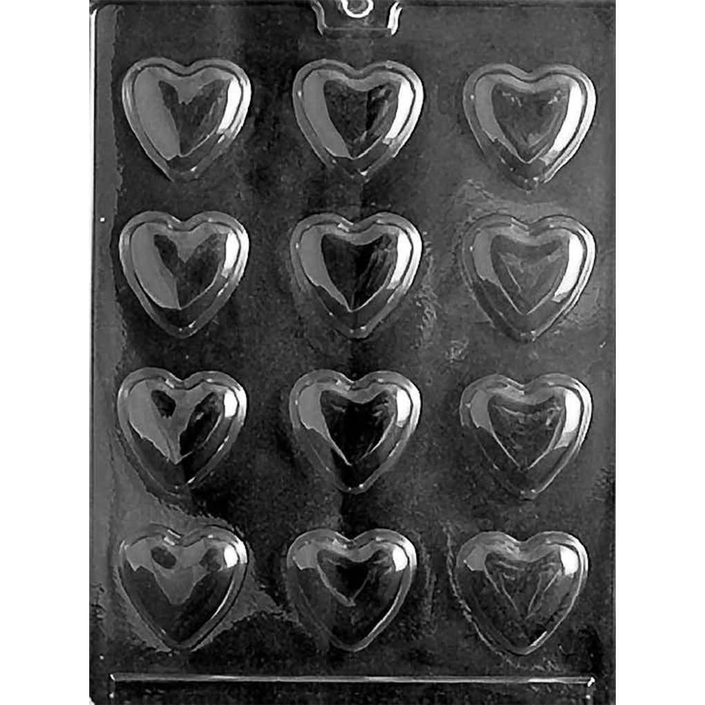 Clear plastic chocolate mold photographed on a black background with twelve medium heart-shaped cavities arranged in rows, each with a smooth heart outline and recessed center.