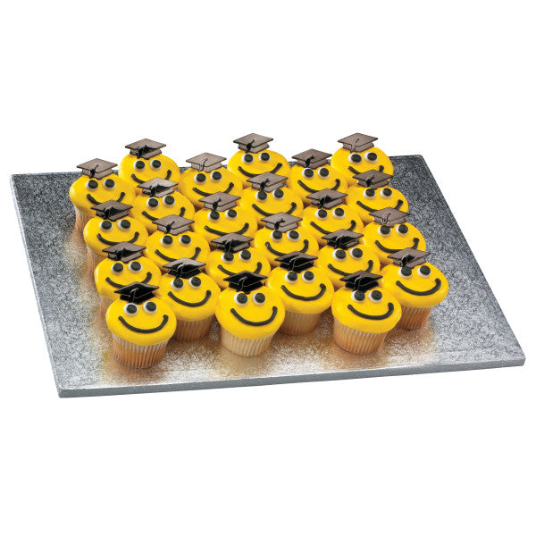 Tray of smiley face cupcakes with yellow icing, googly eyes, and graduation cap toppers.