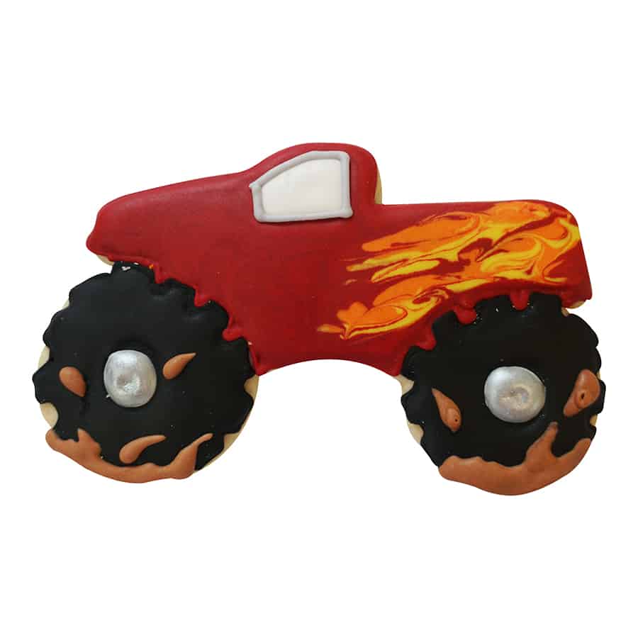 Decorated monster truck cookie with red icing, flame details, and black tires with silver hubcaps.