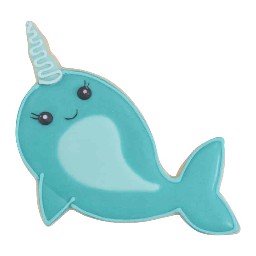 Decorated narwhal cookie with blue icing, a happy face, and a whimsical horn design.