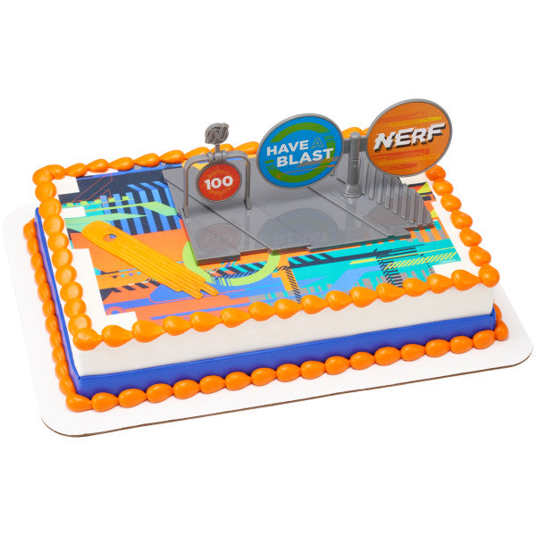Rectangular cake with vibrant multicolored graphic design, decorated with bold orange border icing, featuring the Nerf cake topper set and bright targets, suitable for Nerf-themed party celebrations.