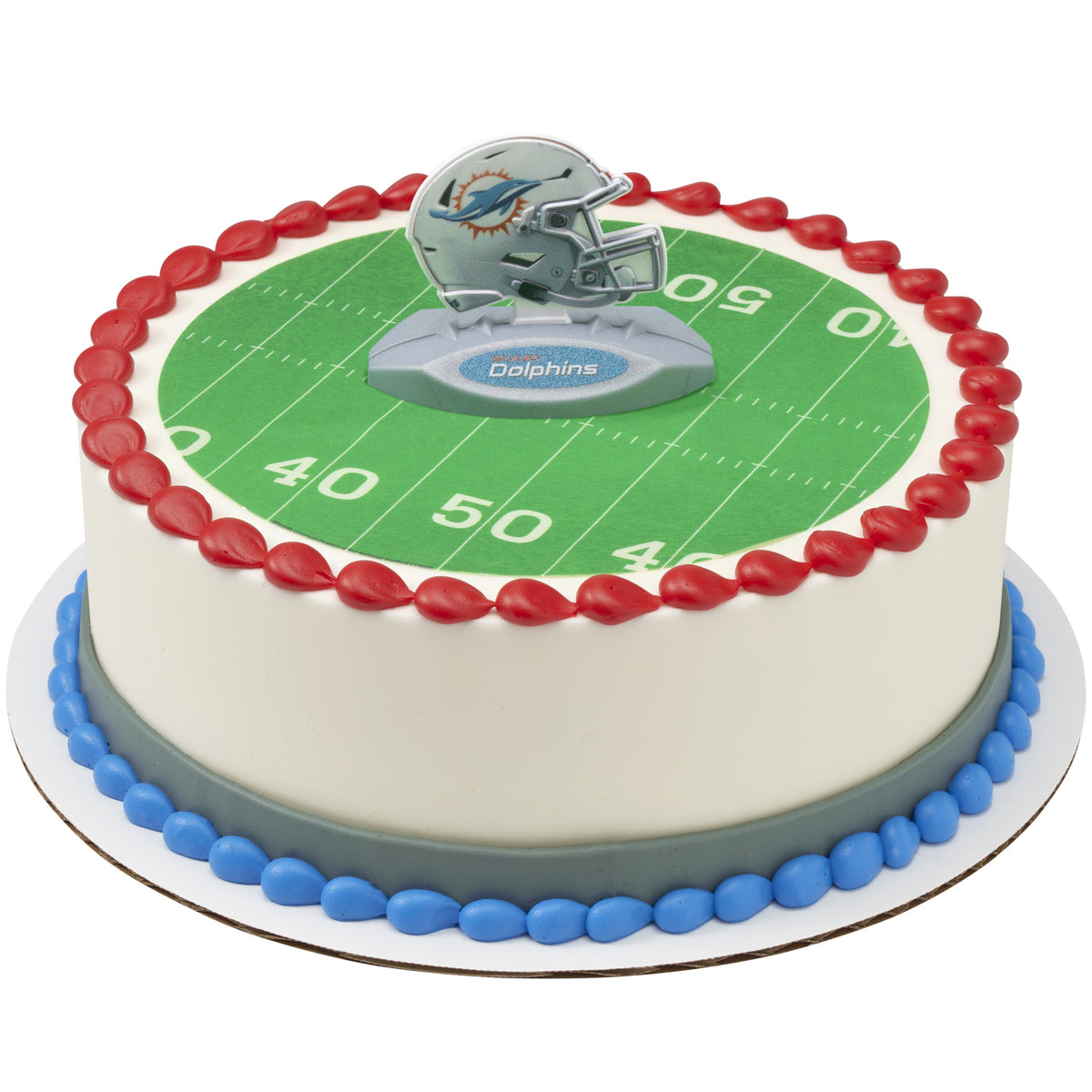 A round cake decorated with a green football field print, red piped border, blue base trim, and a silver-and-blue Dolphins helmet topper on top.