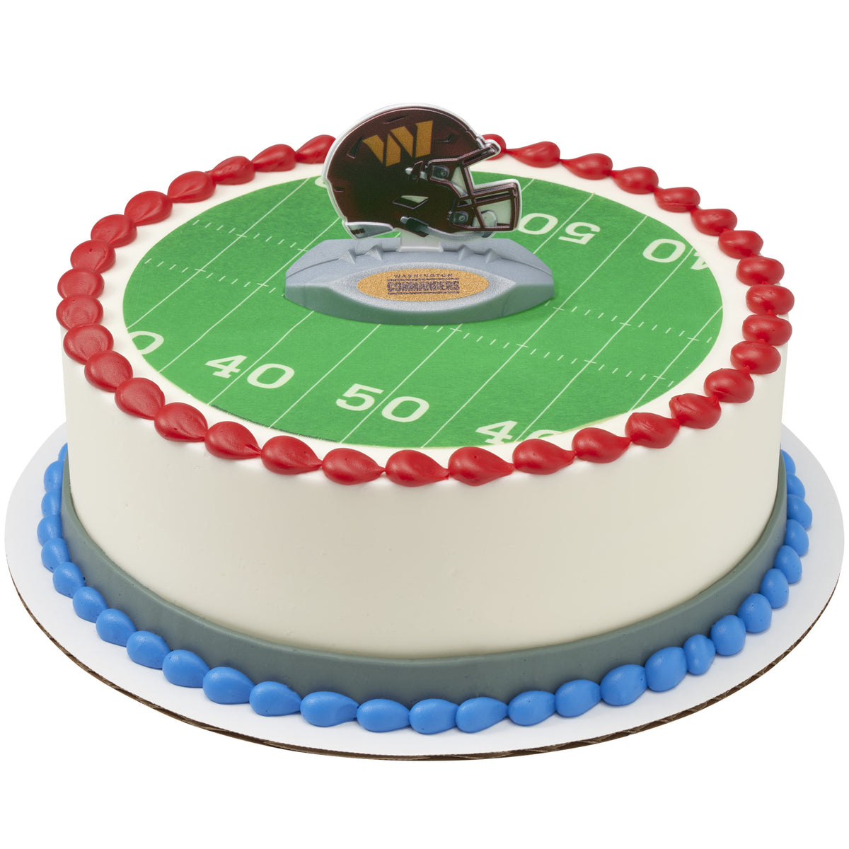 Round white frosted cake decorated with a green football field design, red and blue icing borders, and a Washington Commanders helmet cake topper.